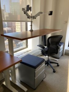 sit/stand trading desk positioned against wall in stand mode