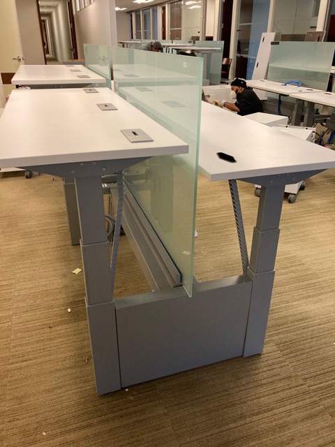 sit/stand trading desks in office adjusted to different heights
