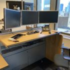 trading desk with 3 monitors adjusted to stand mode