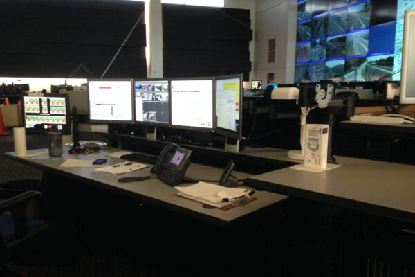 Evans Control room workstation with multiple monitors, phone, and wall video display