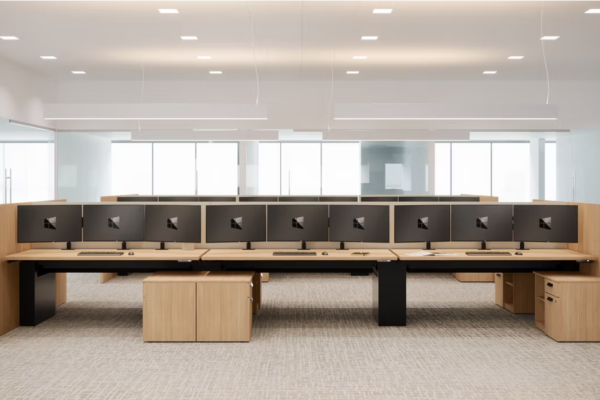 LaCour Modular trading desks with triple monitors and wood finishes in open office